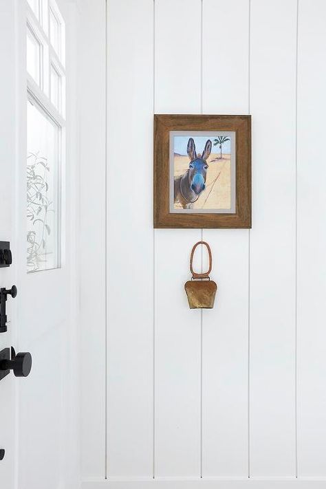 Cottage foyer designed with a vertical shiplap wall and a wood-framed wall art adding the perfect cottage charm. Cottage Foyer, White Cottage Kitchens, Entry Staircase, Salt Interiors, Window Seat Nook, Wet Bar Designs, White Mirror Frame, Pure Salt Interiors, Bungalow Interiors