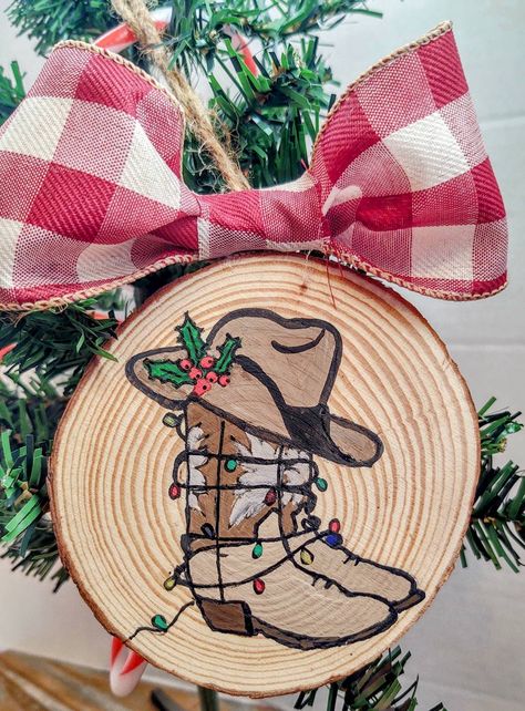 Show your love for the iconic western hat and boots, wrapped in Christmas lights.   Handpainted on 3- 3.4 inch wood slices. Hung on jute twine with a burgundy and cream plaid ribbon bow.   Made to order item. Ships within one week of placing order.    Being handpainted,slight variations may occur. Will remain as close to picture as possible. **Black and white buffalo plaid ribbon will be used if shortage occurs in burgundy. Rudolph The Red Nosed Reindeer Ornaments Diy, Country Ornaments Diy, Western Christmas Painting, Painted Wreath On Wood, Christmas Wood Round Ornaments, Wood Slice Art Ideas, Wood Disk Crafts, Diy Western Christmas Ornaments, Wood Log Crafts Christmas