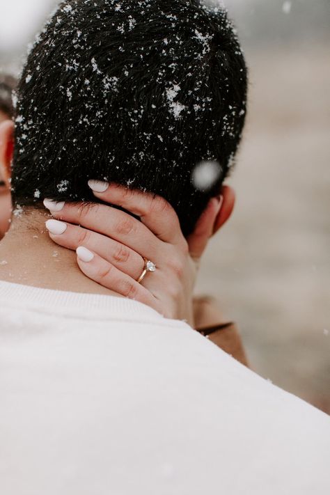 playful engagement session with couple kissing and laughing while about to kiss during their snowy Boulder engagement session holding hands with the Colorado Rocky Mountains behind them with Colorado elopement photographer Diana Coulter