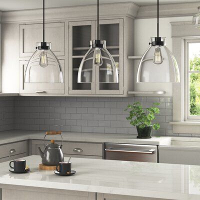 Sleek style and bright illumination come hand-in-hand in this 3-light pendant fixture. Crafted from iron, it features a trio of clear glass bell shades, each adding a luminous element to the industrial aesthetic. Three sockets suit 60W bulbs, which are sold separately, to cast light downward to illuminate your space. Up top, it hangs from a sloped ceiling-compatible bar canopy and three height-adjustable downrods. Best of all, its linear design makes it just right for your kitchen island or dini Lights Over Island, Lights Over Kitchen Island, Island Light Fixtures, Black Kitchen Island, Kitchen Island Pendant, Kitchen Island Linear Pendant, Modern Kitchen Island, Light Kitchen Island, Island Pendant Lights