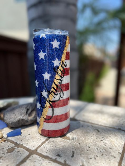 Order a beautiful American flag tumbler to have when celebrating 4th of July or Memorial Day. Better yet just grab one of these patriotic tumblers to show what it means to you. It is an American flag  glitter tumbler that you can personalize. This epoxy tumbler is using FDA compliant epoxy resin that has a beautiful shine. A 20oz skinny tumbler that is a great gift idea  Our tumblers are all stainless steel, double wall, vacuum insulated with a sliding lid, and some come with a straw. It will ke American Tumbler Ideas, Patriotic Tumbler Ideas, Patriotic Tumblers, American Flag Tumbler, Flag Tumbler, Epoxy Tumbler, Water Tumbler, Cup Ideas, Tumbler Ideas