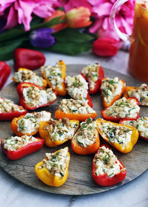 Baked mini bell peppers halves filled with a zucchini, onion, and cream cheese filling on a round wooden platter. Mini Stuffed Peppers, Pepper Boats, Cream Cheese Stuffed Peppers, Bell Pepper Recipes, Cheese Stuffed Peppers, Stuffed Mini Peppers, Vegetarian Appetizers, Cream Cheese Recipes, Cheese Flavor