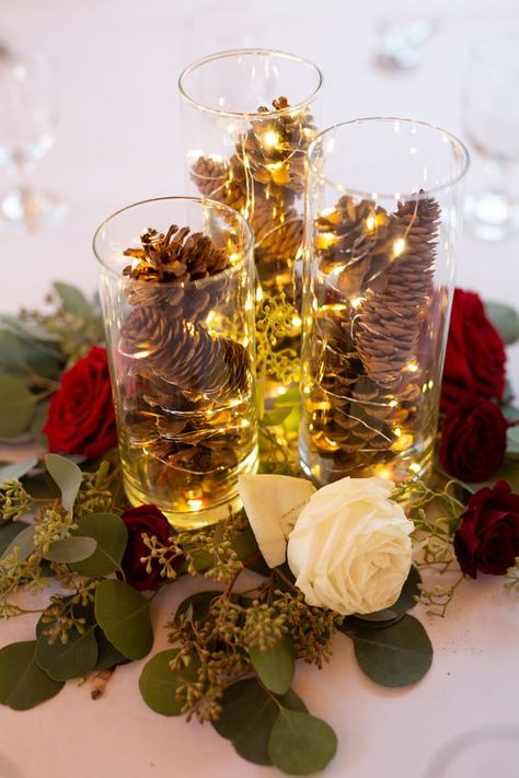 a cute Christmas wedding centerpiece Winter Wedding Pinecones, December Wedding Table Centerpieces, Twinkle Lights Wedding Centerpiece, Pinecone Wedding Centerpiece, Twinkle Lights Centerpiece, Pinecone Wedding Decor, Pinecone Centerpiece Wedding, Winter Centerpieces Wedding, Winter Wedding Centerpieces Elegant