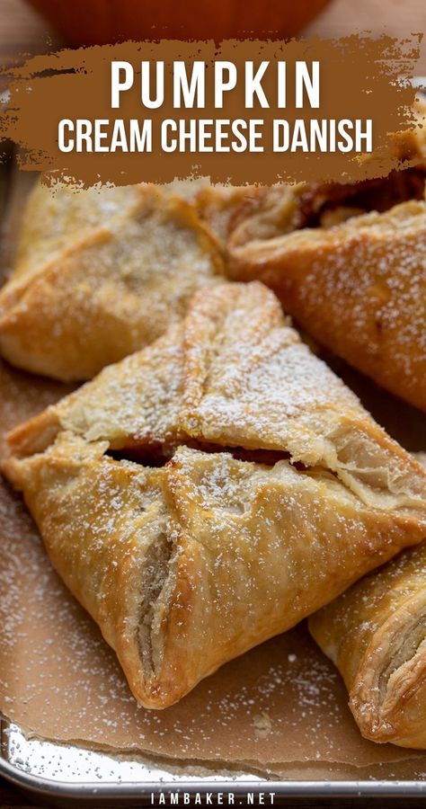 Close-up image of a tray filled with square shaped pumpkin cream cheese danishes dusted with powdered sugar.