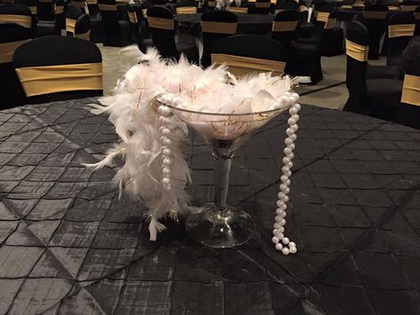 Great Gatsby martini feather boa and pearls centerpiece Gatsby Themed Table Decor, Roaring 20s Centerpieces Vases, Feather Boa Centerpiece, Martini Glass Centerpiece Birthday, Feather Centerpiece Wedding Gatsby, Harlem Nights Party, 1920s Theme, 1920s Decor, Gatsby Gala