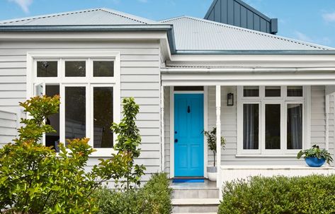 Paint the main walls in a soft grey (here, Dulux Terrace White), then paint trim such as windows and railings in bright white (here, Dulux Vivid White). Add impact – the wow factor – with a brightly coloured door in a shade you love (here, Dulux High Blue) House Paint Exterior Colour Schemes, Popular Grey Paint Colors, Exterior Paint Color Schemes, Weatherboard House, Exterior Paint Color, Paint Color Schemes, Exterior Color Schemes, House Paint Exterior, Exterior Paint Colors