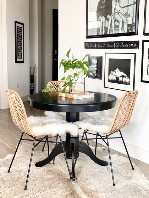 Black table with wicker chairs and sheep skin and a black and white gallery wall! Small Dining Room Gallery Wall, Black Table Kitchen, Small Kitchen Table And Chair Ideas, Rattan Chair Dining Room, Small Dining Table And Chairs, Dining Table For Apartment Small Spaces, Black Table With Brown Chairs, Black Table Light Chairs, Black Rattan Living Room