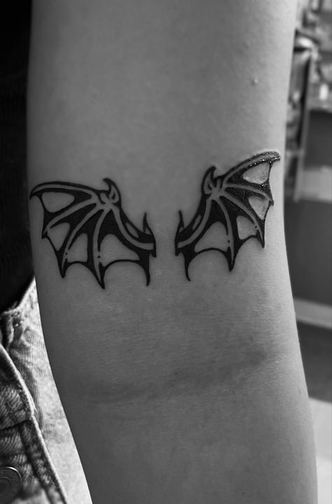 Photo of a bat wings tattoo located above the inner arm ditch Bat Patchwork Tattoo, Spooky Tattoos Traditional, Heart With Bat Wings Tattoo, Batwing Tattoos, Bat Wing Tramp Stamp, Bat Wing Tattoo Back, Collar Bone Tattoo Traditional, Goth Stick And Poke, Bat Outline Tattoo