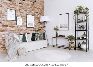 Posters on red brick wall above white sofa with pillows in bright living room interior with plants living room interior royalty free stock images stock  photo Brick Wall Aesthetic, Brick Wall Living Room, Zebra Print Rug, Brick Living Room, Print Rugs, Zebra Decor, Red Brick Walls, Red Brick Wall, Trellis Rug