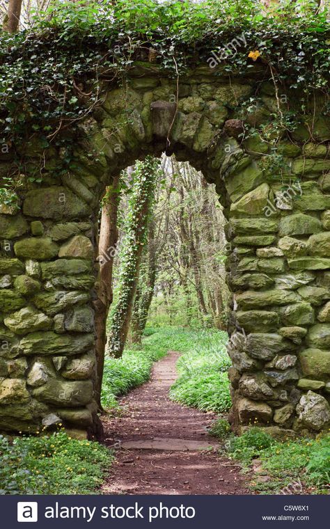 Download this stock image: Stone wall arch over a garden path leading into woodland. UK - C5W6X1 from Alamy's library of millions of high resolution stock photos, illustrations and vectors. Owencore Aesthetic, Castle Archway, Stone Doorway, Anglesey Wales, Wall Arch, Stone Walls Garden, Stone Archway, Lost Garden, Landscaping Retaining Walls