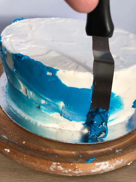 Start spreading the blue icing on the cake in uneven thicknesses. Nasa Cake Ideas, Galaxy Smash Cake, First Trip Around The Sun Cake Ideas, Trip Around The Sun Birthday Cake, Space Themed Smash Cake, Space Smash Cake 1st Birthdays, First Trip Around The Sun Smash Cake, First Trip Around The Sun Cake Smash, First Trip Around The Sun Birthday Party Cake