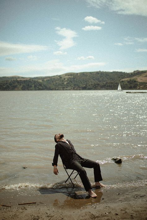 Birthday Shoot Ideas For Men Outdoor, Suit In Water Photoshoot, Chair In Nature Photoshoot, Beach Creative Photography, Stool In Water Photoshoot, Chair In Water Photoshoot, Male Water Photoshoot, Chair In Ocean Photoshoot, Man Slouching In Chair