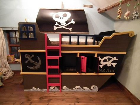 An out-and-outer bunk bed with a hideout. A front panel looks like a starboard of a pirate ship. Bed is of wood with a brown and black finish, white skull and crossbones motifs, greyish bubbling breakers, a grey anchor, a red ladder and doors. Pirate Bedroom Decor, Bathroom Western, Ship Bed, Pirate Ship Bed, Pirate Bedding, Pirate Bedroom, Pirate Room, Modern Bunk Beds, Kids Loft Beds