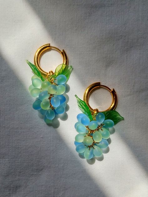 These beautiful earrings are the perfect accessory to add some colour to your outfit. It is handmade using colourful Czech glass beads and murano leaf beads. The grape shape hangs from a hoop made of gold pleated stainless steel. The measurement of the hoops is approximately 2 cm and the overall measurement of the earrigs is 5 cm. Wear alone or layer it with other earrings for the ultimate stylish look!  CARE INSTRUCTIONS It is highly recommended to avoid lotion, perfume and other cosmetics to b Hoop Earrings With Charm, Earrings Food, Grape Design, Grape Earrings, Earrings Gold Hoop, Fruit Earrings, Crystal Figurines, Food Jewelry, Earrings Unique