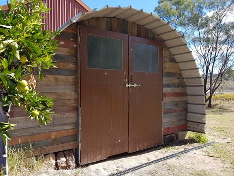 Shed built from recycled materials. Trampoline frame, old pallets, 2nd hand doors, window and roofing sheets. Most of the screws and bolts were salvaged as well. Repurposed Trampoline, Recycled Trampoline, Nissen Hut, Hut Ideas, Old Trampoline, Shed Diy, Bin House, Grain Bin House, Grain Bins