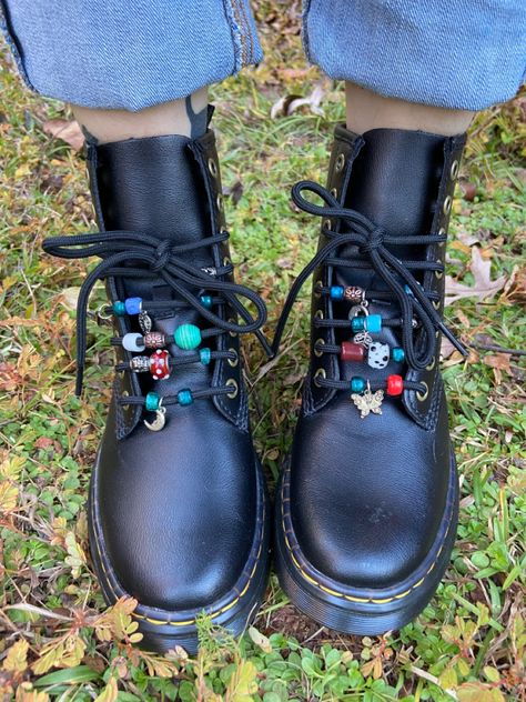 Black doc marten boots with different colored glass beads on the laces Doc Martens Beads On Laces, Upcycled Doc Martens, Decorating Doc Martens, Doc Marten Ribbon Laces, Doc Martens Beads, Beaded Doc Martens, Dr Martens Accessories, Diy Combat Boots, Shoe Charms Doc Martens