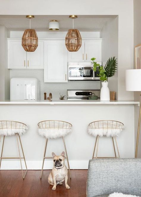 A white Smeg fridge in a transitional kitchen brings a vintage vibe surrounding white shaker cabinets, a marble-like kitchen peninsula and gold barstools. Small Parisian Apartment, Bachelorette Apartment, Apartment Living Room Decor Ideas, Apartment Living Room Decor, Emily Henderson Design, Decor Pad, Cream Kitchen, Kitchen Backsplash Ideas, Beach House Kitchens