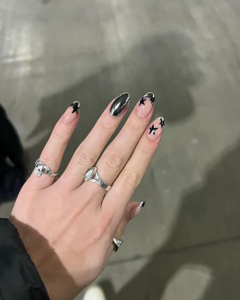 Gel nails | nail inspo | nail 2024 | new years nails | cool girl nails | New york nails | nail art | nail designs | chrome nails | star nails | almond nails | black nailz | cheome nails | 2024 nail inspo Chrome And Star Nails, Black Chrome Star Nails, Silver Nails With Black Stars, Silver Chrome Star Nails, Black And Silver Star Nails, Black Nails Inspo Aesthetic, Black And Silver Chrome Nails, Star Nails Almond, Black And Chrome Nails