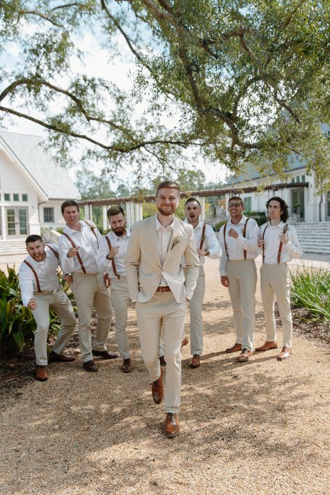 Groom walks toward the camera while groomsmen hype him up from behind Suspender Groomsmen Attire, Khaki Suspenders Groomsmen, Groomsmen Beige Pants, Beige Suspenders Groomsmen, White Button Down Groomsmen, Beach Wedding Suspenders Groomsmen, Khaki Linen Suit Wedding, Italy Wedding Groomsmen, Beige Groomsmen Suits Suspenders