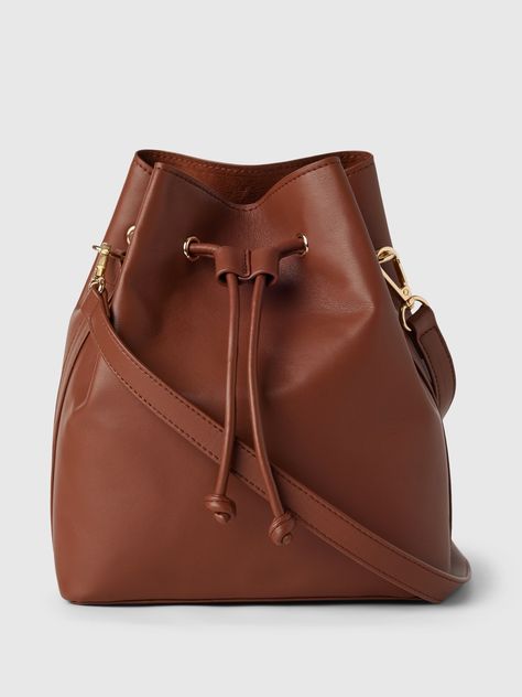 This bucket bag is made with vegan leather.  Shoulder strap.  Drawcord closure at top.  Inner pocket.  Faux suede lining.  Dimensions: 9"H x 4" W x 7. 5" L Bucket Purse, Chic Summer Outfits, Makeup Rooms, Fall Fits, Leather Bucket Bag, Leather Bucket, Work Life, The Gap, Purse Wallet