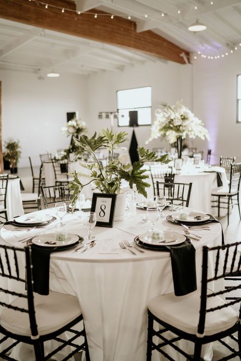 Black And White Wedding On A Budget, Black And White Wedding With A Pop Of Colour, Cheap Black And White Wedding Decor, Classy Black White Wedding, Black White And Silver Wedding Centerpieces, Gold Chargers Wedding Place Settings Round Table, Spring Wedding Black And White, Black Tablecloth Wedding White Chairs, Black And White Affair Wedding