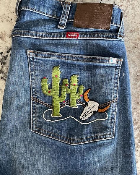 SoOlive Upcycled Denim. Western desert scene on back pocket of Men’s Wrangler Relaxed Boot 34x32 What would you like on your pocket or… | Instagram Denim Embroidery Jeans Men, Jean Pocket Painting, Painting Pants, Western Photos, Country Jeans, Boro Sashiko, Country Outfit, Western Embroidery, Rustic Rose