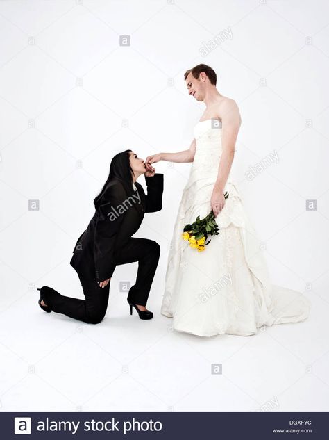 Bride wearing a suit kissing the hand of a groom wearing a wedding dress, exchange of wedding clothing, Austria Female Wedding Suit, Guys In Skirts, Bride Suit, Clothes Swap, Asian Style Dress, Funny Dresses, Woman In Suit, Role Reversal, Eid Outfits