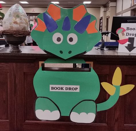 Dinosaur book drop, library book drop, book return. Dinosaur Derby, Indoor book drop. Book Drop Box Library, Bookdrop Decor, Book Return Ideas Library, Book Drop Ideas Library, Dinovember At The Library, Library Book Drop, Library Walls, Book Return, Dinosaur Classroom