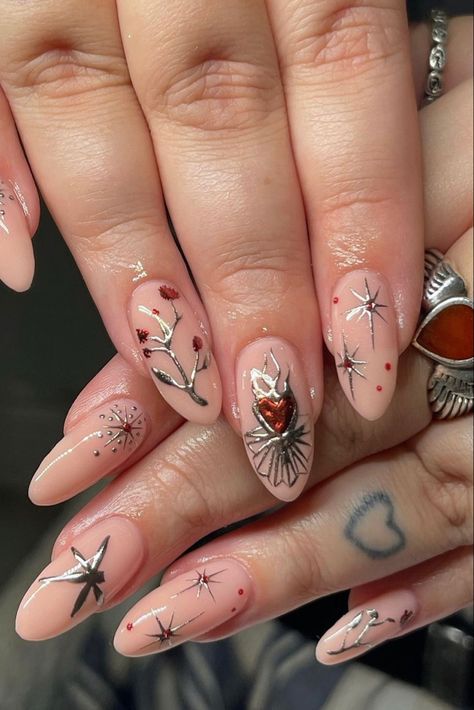 A photo of nude nails with silver and red designs on them including branches and stars. The hands are sitting on top of one another. Acotar Acrylic Nails, Astarion Nails, Targaryen Nails, Hades Nails, Winter Solstice Nails, Yule Nails, Game Of Thrones Nails, Acotar Nails, Nails 2022 Winter