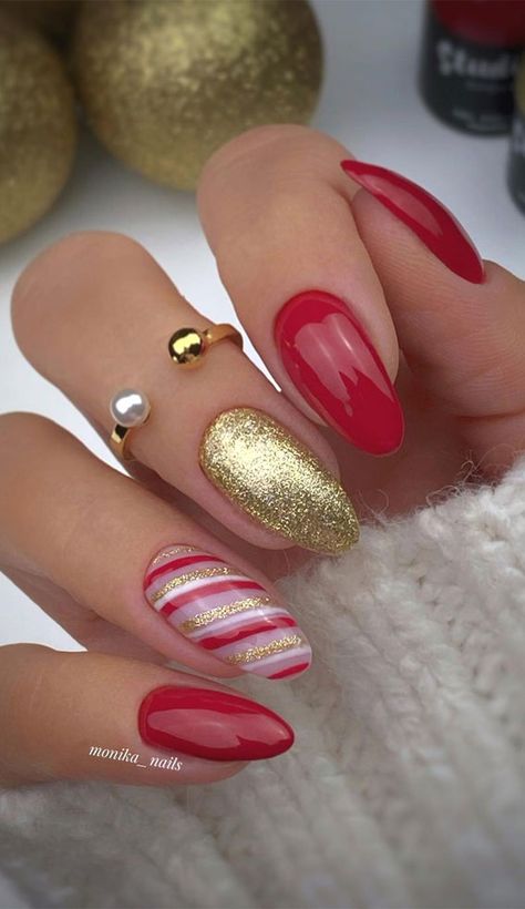 39. Gold and Red Christmas nails A pretty, stylish festive nail set. The nails feature red and gold glitter nails. One nail has candy... Festive Nail Colors, Red And Gold Nails, Candy Cane Nails, Red Christmas Nails, Cute Christmas Nails, Christmas Nails Easy, Christmas Gel Nails, Nails Easy, Christmas Nails Acrylic