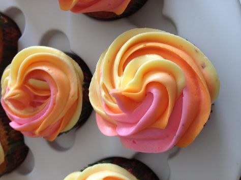 These are the cupcakes before the star topper. I love the "rainbow" frosting of pink, yellow and orange Two Groovy Cupcake Ideas, Pink Orange Yellow Party Theme, Pink And Orange Cupcake Ideas, Groovy Cupcakes Ideas, Two Groovy Cupcakes, Pink And Orange Cupcakes, Yellow And Pink Baby Shower Ideas, Pink And Yellow Baby Shower Ideas, Pink Orange Ombre Cake