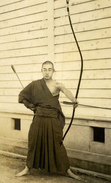 Kyudo - Way of the Bow 1930s    The Yumi (Japanese Bow) is an asymmetrical longbow over two metres in height that is traditionally made of bamboo, wood and leather, while the Ya (arrows) of this period have bamboo shafts with eagle or hawk feather fletchings. Practiced for centuries as both a Gendai budo (Martial Art) and a form of Zen meditation, the sport of Kyudo is still widely studied throughout Japan. Kyudo Archery, Yumi Bow, Hawk Feather, Real Samurai, Guerriero Samurai, Hidden Dragon, Crouching Tiger, Traditional Archery, Longbow