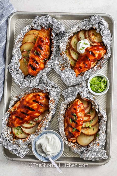 These portable chicken foil packets are ideal for picnics, camping trips, and days at the beach. Chicken and potatoes are marinated in garlic butter and BBQ sauce, wrapped in foil, then grilled to tasty perfection. Enjoy them alone or pair them with veggies or salad for a full meal. This easy recipe is sure to become a family favorite. Experiment with ranch seasoning or other variations for a fresh twist each time. #theshortcutkitchen Easy Meals For Beach Trip, Foil Packet Dinners For The Grill, Camp Foil Packets, Bbq Chicken Foil Packets For The Oven, Chicken In Foil Packets Ovens, Easy Beach Meals Lunches, Foil Packets For Camping, Foil Packets For The Grill, Foil Chicken