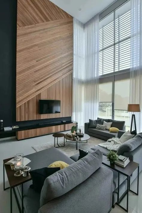 A contemporary double height living room in the shades of grey, with an accent wood slat wall, a TV and a TV unit, double height windows that bring a lot of light Tall Tv Wall, Wall With Tv, Tall Wall Decor, Double Height Living Room, Contemporary Decor Living Room, Curtains Decor, Wood Interior Design, Double Height, Trendy Living Rooms