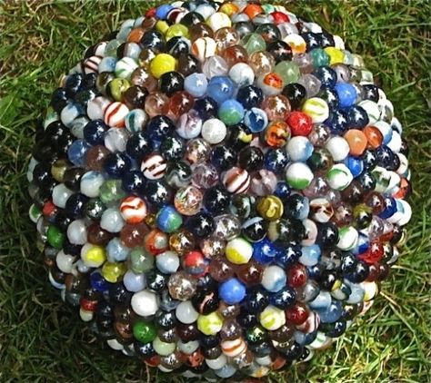 15 Ways To Turn Glass Marbles Into Home Decor And More - When my kids were younger, we had so many marbles. Seriously, those little things could be found in every crack and corner of my house. Now that the kids have sort of outgrown their marble playing days, I started thinking about what I could do with those marbles. I mean, we’re talking so many marbles! #repurpose #upcycle #reuse #diy #crafts #homedecor #projects Diy Marble Crafts, Bowling Ball Garden, Mosaic Bowling Ball, Bowling Ball Yard Art, Bowling Ball Art, Marbles Crafts, Recycled Garden Art, Garden Globes, Garden Balls