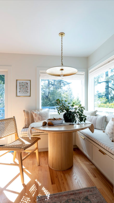 Our hearts are captivated by this charming white oak wood table with its rounded design, seamlessly complementing the dining area. The table's circular shape adds a dynamic touch to the nook, while simultaneously transforming it into a sculptural statement piece. Paired with a slender brass pendant light, the kitchen exudes an illuminated and airy ambiance. Round Table With Bench Seating, Light Airy Kitchen, Circle Dining Room Table, Circular Dining Room Table, Airy Kitchen, Shaker Cabinet Doors, Dining Roo, Circular Dining Table, Round Kitchen Table