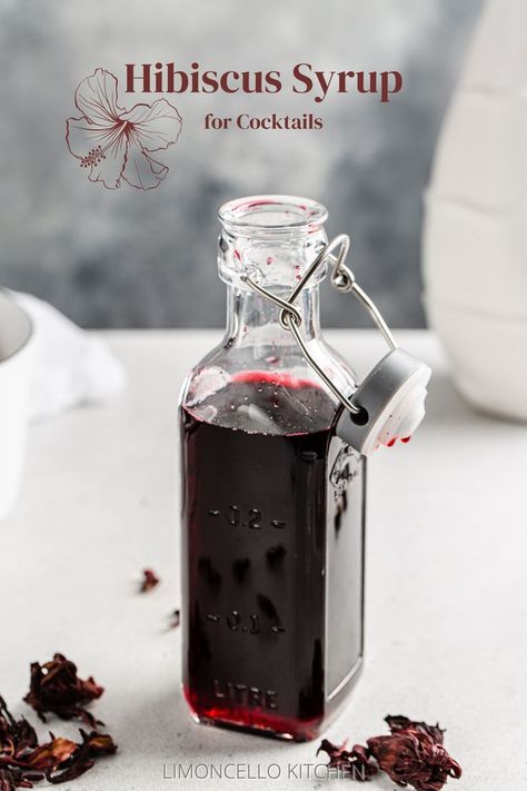 Bottle of hibiscus syrup with dried hibiscus flowers around it and the text Hibiscus Syrup for Cocktails on top. Hibiscus Simple Syrup Recipe, Margarita Simple Syrup, Hibiscus Cocktail, Pitcher Of Margaritas, Hibiscus Drink, Hibiscus Syrup, Simple Syrup Cocktails, Dried Hibiscus Flowers, Simple Syrup Recipes