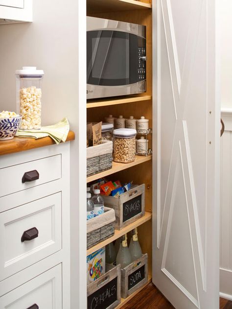 Know exactly what you have with see-through containers that keep items fresh and tidy. This method also helps cooks to know when to replace items in the containers. Microwave In Pantry, Hidden Microwave, Wooden Bins, Remodeling Trends, Organized Pantry, Pantry Closet, Kitchen Hacks Organization, Pantry Design, Multifunctional Furniture