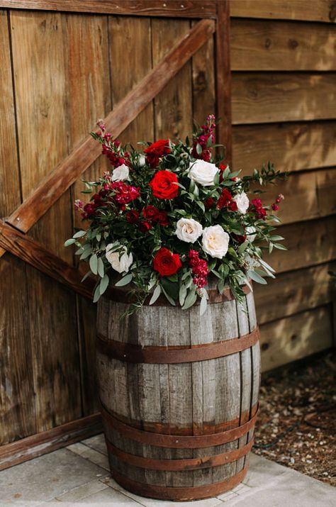 A Rustic And Elegant Barn Wedding In Bayou Country Wine Barrels With Florals And Barn Floral Arrangement On Wine Barrel, Christmas Wedding Arbor Ideas, Christmas Wedding Rustic, Christmas Country Wedding Ideas, December Wedding Decorations Wedding Table Decor, Christmas Rustic Wedding, Christmas Wedding In Florida, Country Christmas Wedding Ideas, Western Christmas Wedding Ideas