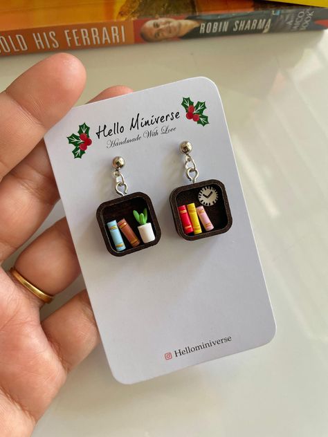 "These Miniature Square Shape Bookshelf Earrings are perfect for those who loves Books !  This is a 100% hand-made realistic fake Bookcase miniature. Now you can have your favourite Bookcase as a Miniature earrings. \"Hello Miniverse\" creates uniquely handmade inspired Bookcase  Earrings that look as gorgeous as the real thing.  I make sure packaging is high quality to sustain rough handling by courier service during transit. Dispatch time: Within 15 days.  Delivery time:  Domestic: 5-6 Days International: 20-25 days. Care: Please treat the Bookshelf with care. Remove dust with a piece of soft fabric, a brush or a sponge. Protect the product from damages. Do not drop. If you have any question about this listing or anything else, please feel free to contact me. I will get to you as soon as Bookshelf Earrings, Miniature Earrings, Earring Packaging, Librarian Gifts, Weird Jewelry, Book Earrings, Earrings Square, Handmade Packaging, Miniature Book