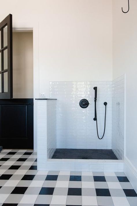 White, gray and black plaid floor tiles in a mudroom completed with a doggy shower showcasing white stacked tiles and black floor tiles. Plaid Floor, Contemporary Laundry Room, White Laundry Rooms, Black Floor Tiles, Stylish Laundry Room, Dog Washing Station, Laundry Room Flooring, Dream Laundry Room, Mudroom Laundry Room