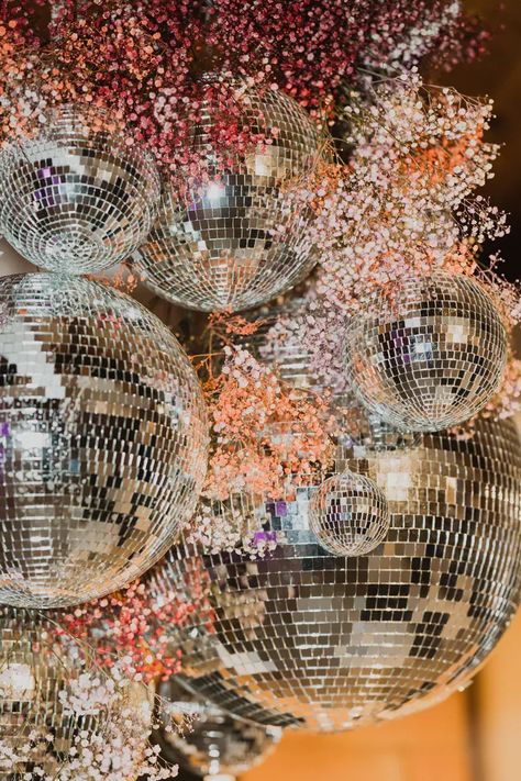 Custom made hanging installation for wedding dance floor with sprays of colorful small blooms and varying sizes of mirrored disco balls. Christmas Wedding Dance Floor, Disco Ball Arrangement, Disco Ball Dance Floor, Hannah And Samuel, Disco Ball Installation, Disco Ball Wedding Decor, Wedding Installation, Disco Ball Aesthetic, Ball Installation