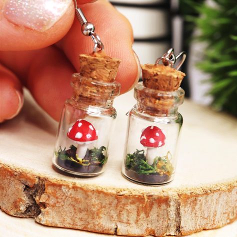 This Mushroom Terrarium Jar Earrings will definitely make your days happier! :) If you love to wear mini mushroom jewelry, or you are looking for the perfect fall earrings to a toadstool lover, then you came to the right place! Complete the set with the matching MininiLand Mushroom Necklace here: https://www.etsy.com/shop/MininiLand?section_id=37720351 ;) D E T A I L S: * Handmade Mushroom Terrarium Jar Earrings * Made from Polymer Clay and a tiny glass jar * Length: 1.6 inches (4 cm) * Earring Mushroom Terrarium, Jar Earrings, Eco Gift Wrapping, Earrings Cottagecore, Tiny Glass Jars, Terrarium Jar, Cottagecore Earrings, Mini Mushroom, Mushroom Necklace