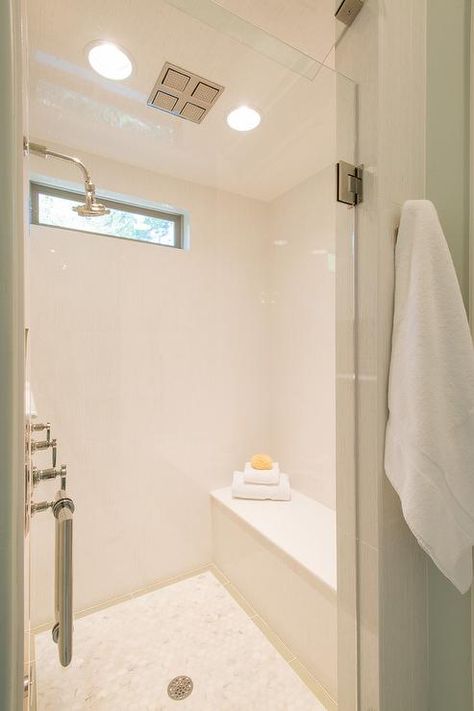 Fabulous white shower features a white tile surround framing a high narrow window over a shower bench facing a shower head. Transom Window Shower Master Bath, Shower With Transom Window, Narrow Horizontal Window, Bathroom Ventilation Window Design, Shower Windows, Bathroom Windows In Shower, Narrow Window, Shower Window, Glass Showers