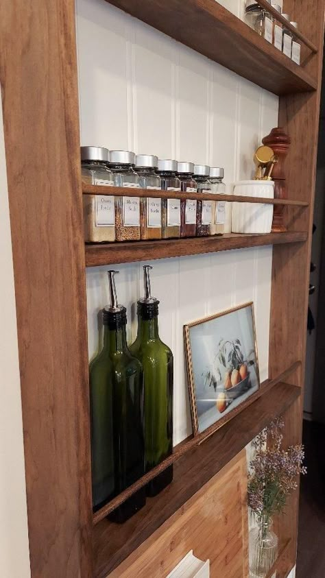 The spice rack is finished, and my kitchen has never looked cozier. It adds so much beauty and function to our space! I have more details saved to the wall rack highlight on my page, so check that out and let me know when you plan on putting one of these beauties in your kitchen. Check out my LTK of you need any 🔗 Stain: @minwaxusa provincial Beadboard: @sherwinwilliams snowbound #wallrack #platerack #modernvintage #kitchenstorage #kitchendesign #kitchenrefresh #diy #diyshelves #doablediy Ikea Spice Rack Bookshelves, Kitchen Spices Shelves, Wall Shelves Pantry, Extra Storage Ideas Kitchen, Diy Kitchen Spice Rack Ideas, End Kitchen Cabinet Shelves, End Of Upper Kitchen Cabinet Ideas, Kitchen Wall Decor With Shelves, Recipe Bookshelf In Kitchen