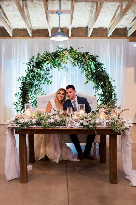 Click to see more from this neutral, coastal inspired wedding! Sweetheart table using an infinity arch and white draping as the backdrop.  #sweethearttablewedding #sweethearttablebackdrop #orlando Bride And Groom Table Background, Sweetheart Table Wedding Backdrop, Wedding Couple Table, Sweetheart Table Backdrop, Wedding Sweetheart Table, Bride Groom Table, Simple Beach Wedding, Sweetheart Table Decor, Head Table Decor