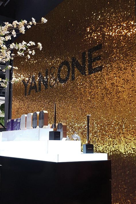 Gold and dark brown sequin wall behind a cosmetic display in a retail chain store. Sequin Wall Backdrop, Luxury Window Display, Gold Display, Confetti Wall, Standee Design, Sequin Wall, New Years Wedding, Christmas Luxury, Store Window Display