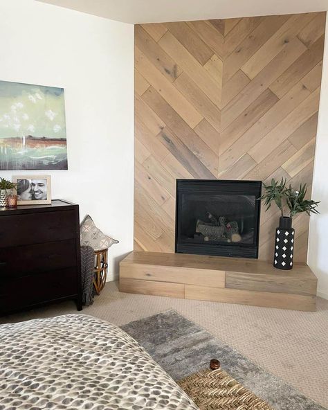 Wood-look shiplap in a herringbone pattern with an inset black fireplace creates an eye-catching feature wall. A patterned black and white vase sits on the wooden tile hearth. Wood Tile Wall Accent, Vertical Shiplap Fireplace Wall, Herringbone Shiplap, Tile Hearth, Herringbone Fireplace, Wood Wall Tiles, Inset Fireplace, Black And White Vase, Shiplap Accent Wall