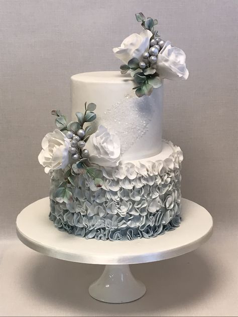 Amaka, 2 tier wintery theme wedding cake with blue/grey ombre ruffle bottom tier and sprays of white sugar roses, brunia berries and eucalyptus foliage Wedding Cake Designs 2 Tier, Wedding Cake With Blue, Brunia Berries, Ruffle Wedding Cake, Charlotte Cake, 25 Anniversary, Tiered Cakes Birthday, Tiered Cake Design, Silver Wedding Cake