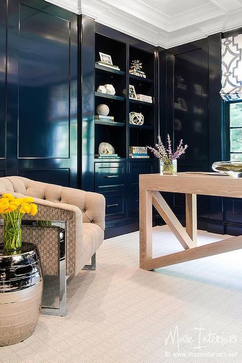 Navy paneled office boasts a tufted linen chair and a chrome stool table stands in front of a navy blue lacquered built-in shelves. Blue Library, Blue Home Offices, Den Library, Fine Paints Of Europe, Blue Painted Furniture, Lacquered Walls, Library Office, Contemporary Desk, Modern Shelf